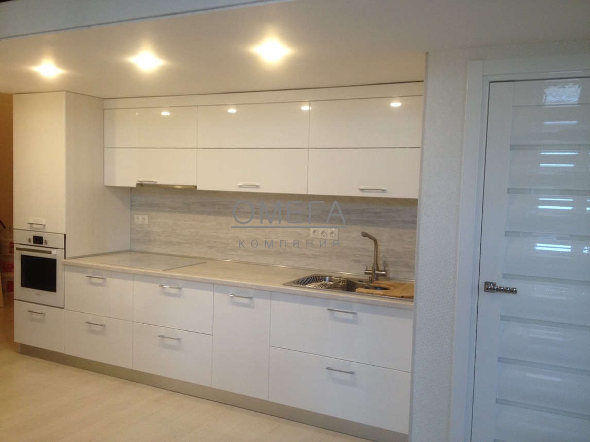 Белый кухонный гарнитур в современном стиле для квартиры студии. Глянцевые фасады, столешница СКИФ.