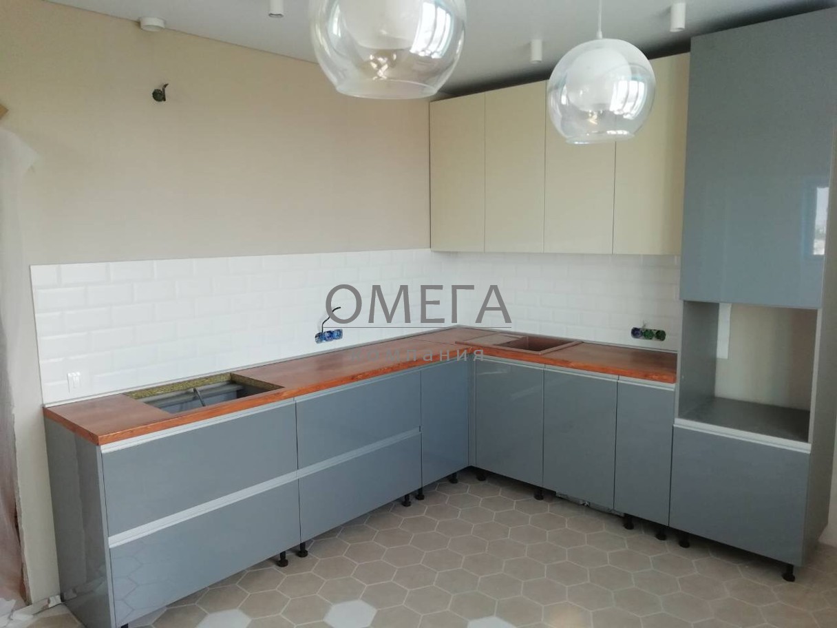 Угловая кухня с глянцевыми фасадами бежевого и серого цвета на заказ в Челябинске недорого от производителя